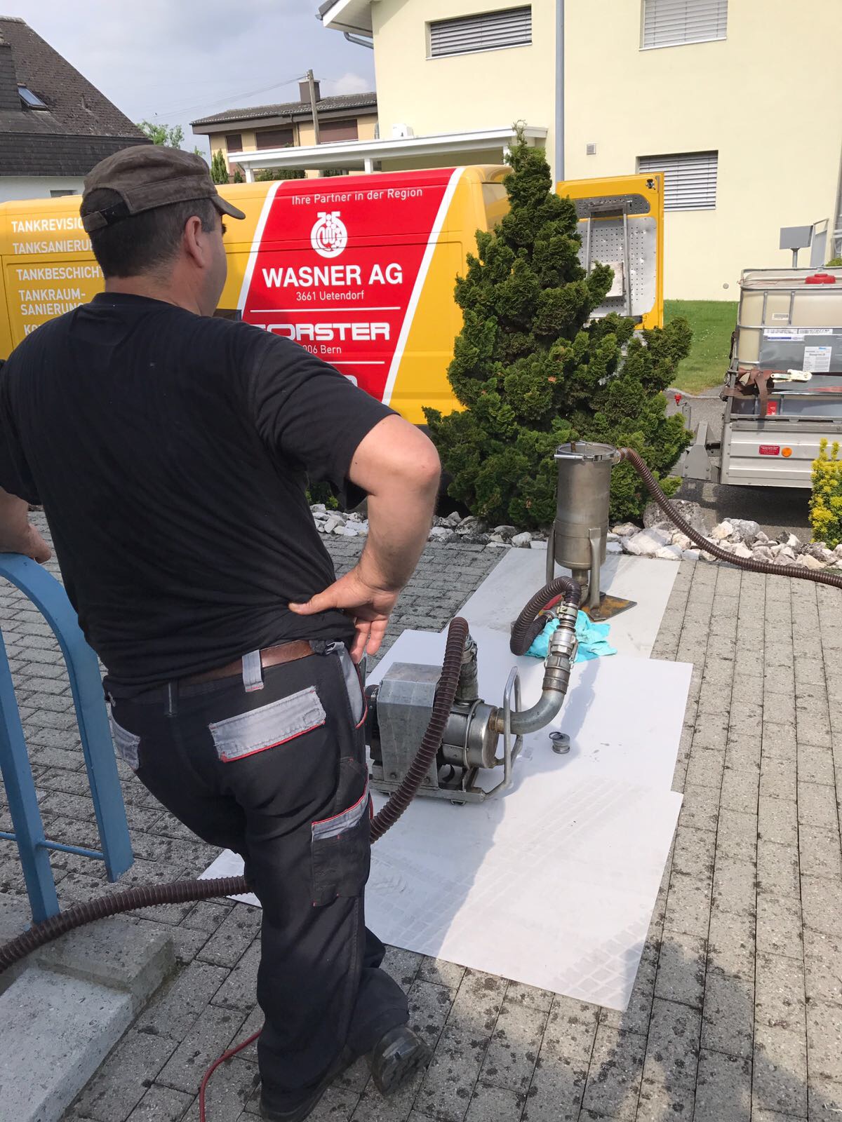 Mann bedient Ölfilteranlage draußen.